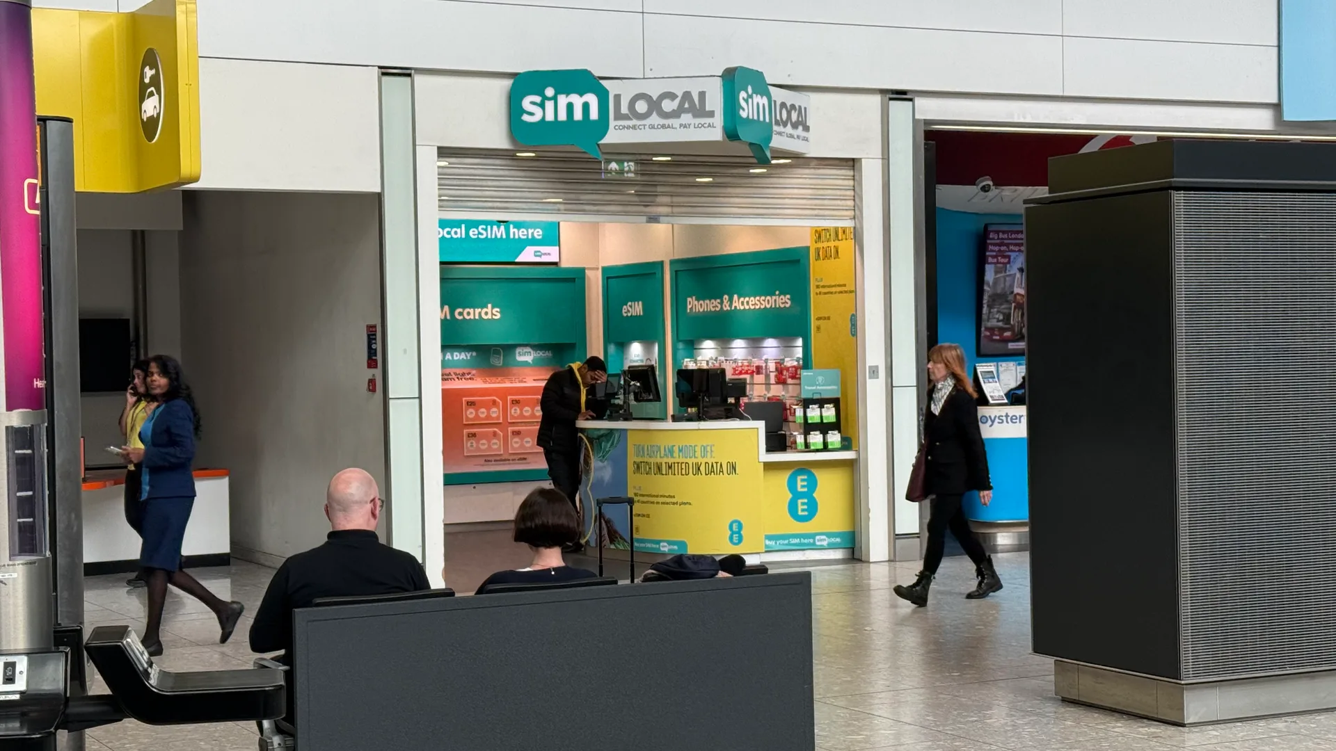 Sim Local shop in the arrivals area of Heathrow Terminal 5, with signs for SIM cards, eSIMs and an EE offer