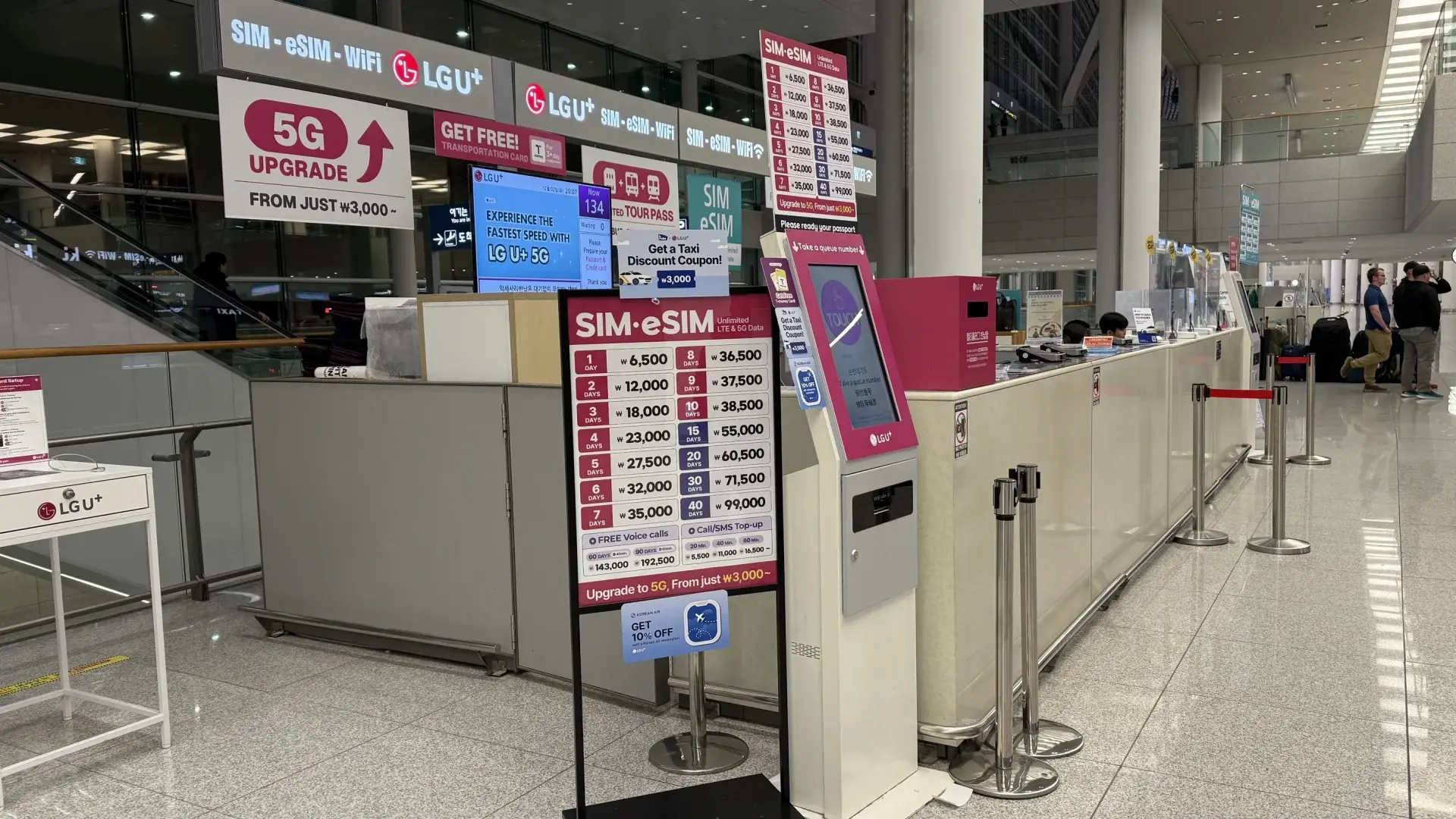 Counter area at Incheon Airport with LG U+ SIM and eSIM service desks, price boards and kiosks for purchasing mobile plans upon arrival